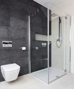 Modernes Bad mit Glas-Eckdusche, Regendusche, dunkler Wand – hochwertige Duschkabinen in Frankfurt für stilvolle Badezimmergestaltung