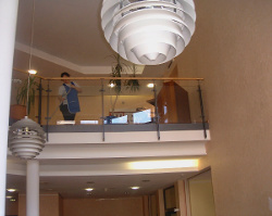 Treppenhaus mit transparentem Glasgeländer, stilvoll gestaltet, hell erleuchtet, Glasgeländer in Frankfurt.