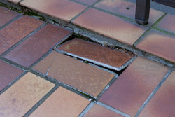 Hier ist eine Terrassensanierung nötig. Die Fliesen heben sich.